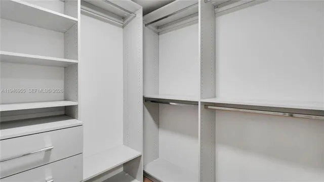 a view of walk in closet with empty racks