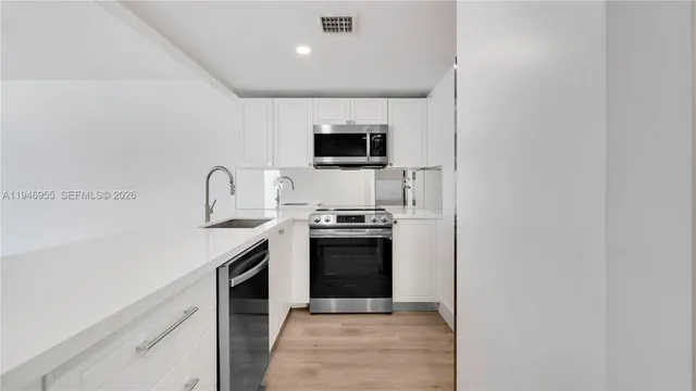 a view of kitchen with wooden floor and electronic appliances