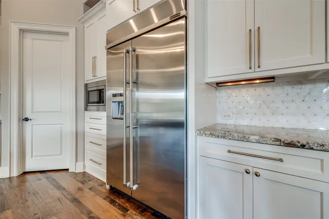 a kitchen with granite countertop a refrigerator and a stove