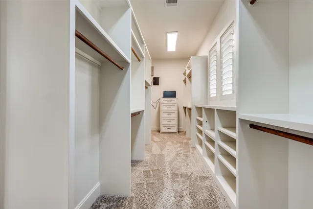 a view of walk in closet with empty racks