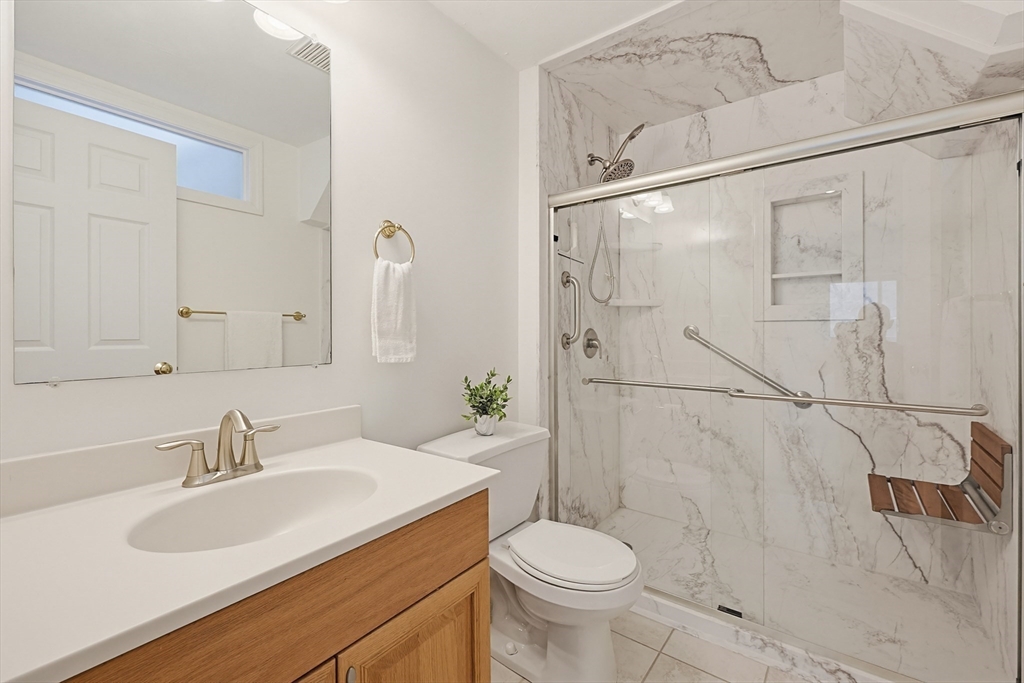3002 Maple Brook Road, Unit 3002 Bellingham, MA 02019 - Photo 29 of 42 a bathroom with a sink toilet a mirror and shower