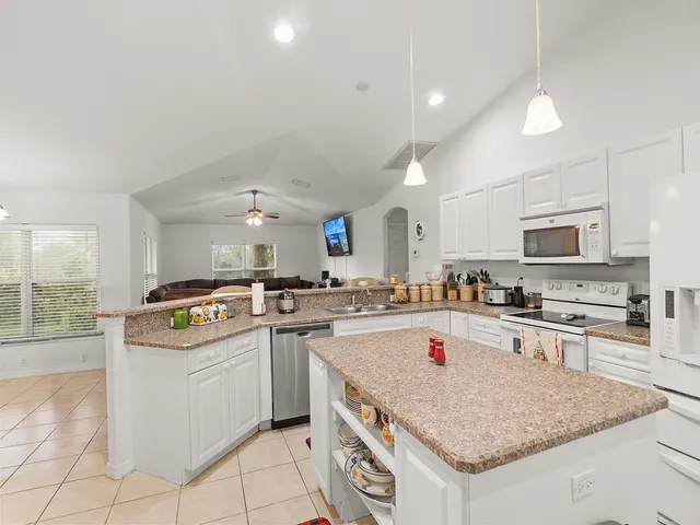 a kitchen with counter top space appliances and wooden floor