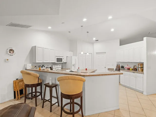 a kitchen with cabinets a sink and chairs