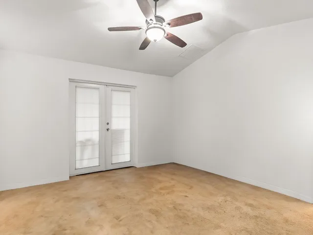 an empty room with chandelier fan