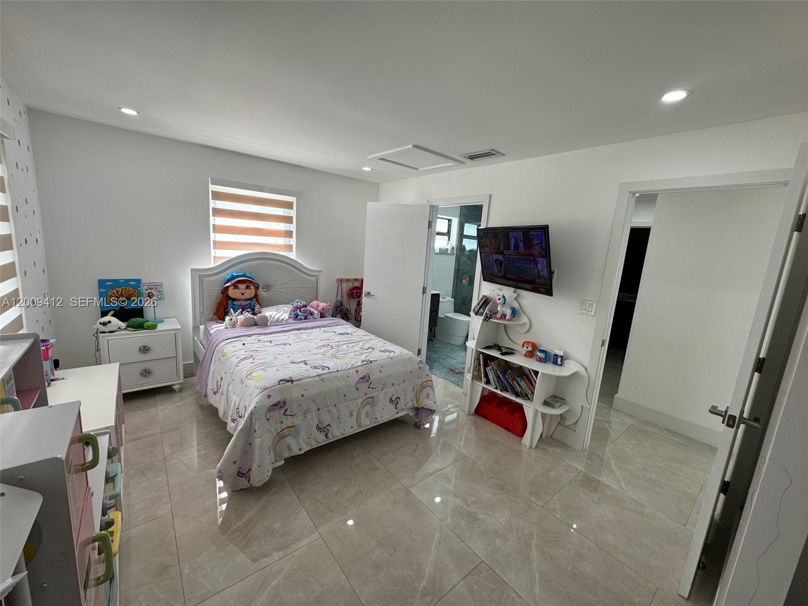 18781 Southwest 294th Terrace Homestead, FL 33030 - Photo 23 of 44 a bedroom with a bed a flat screen tv and a window