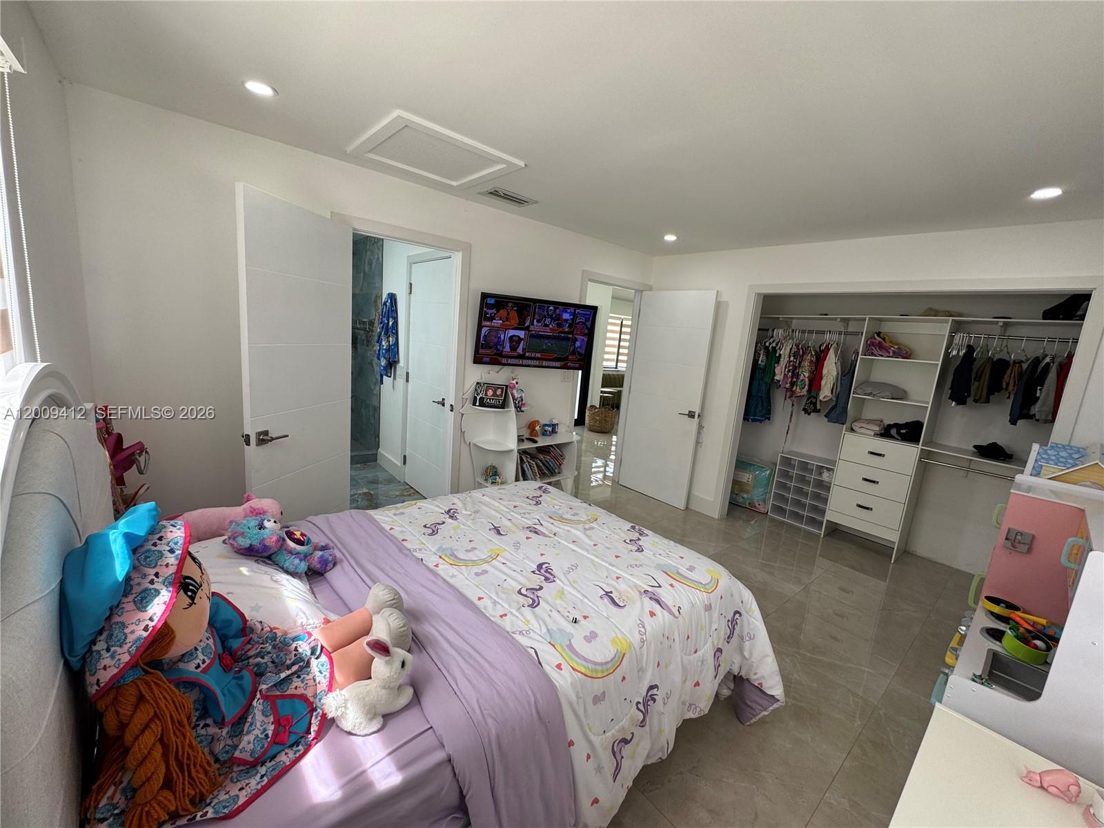 18781 Southwest 294th Terrace Homestead, FL 33030 - Photo 24 of 44 a bed room with a bed a couch and a flat screen tv