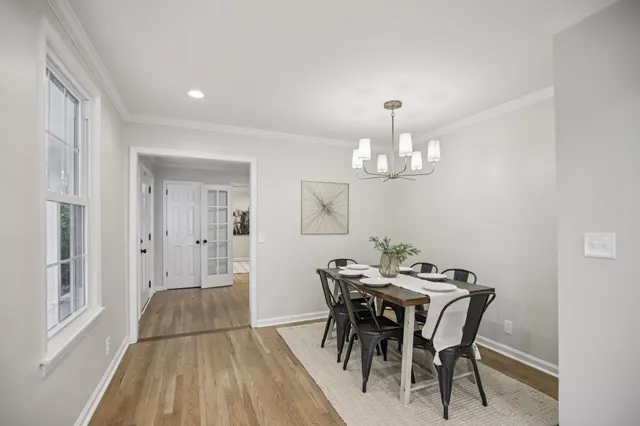 a view of a dining room with furniture a chandelier and wooden floor