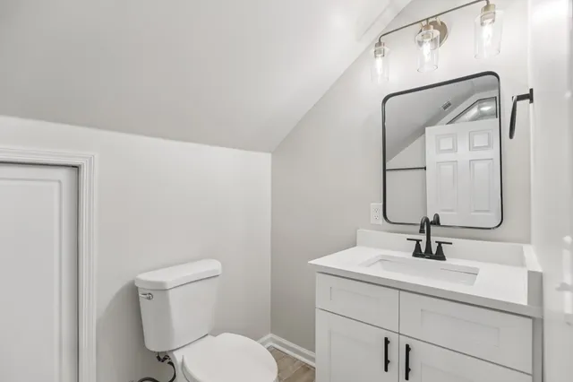 a bathroom with a toilet a sink and mirror