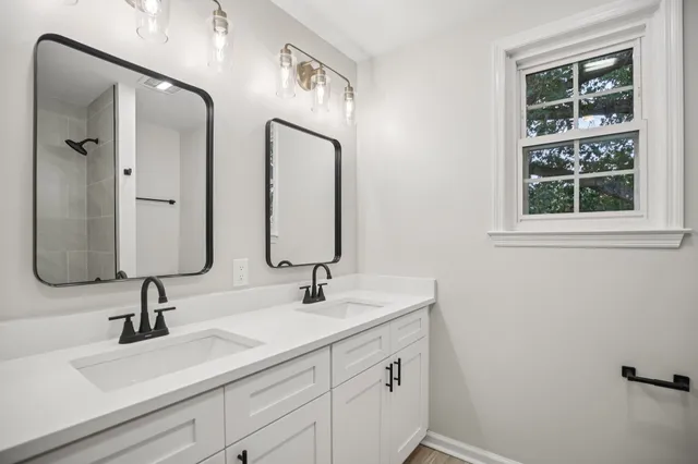 a bathroom with double vanity sink and two mirror