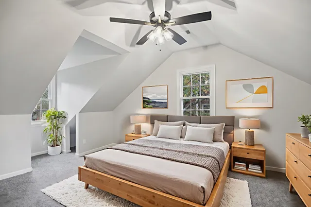 a bedroom with a bed chandelier and a window