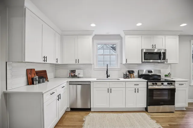 a kitchen with a sink a stove and cabinets