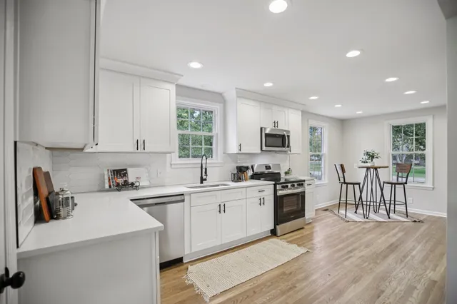 a kitchen with white cabinets sink and stainless steel appliances
