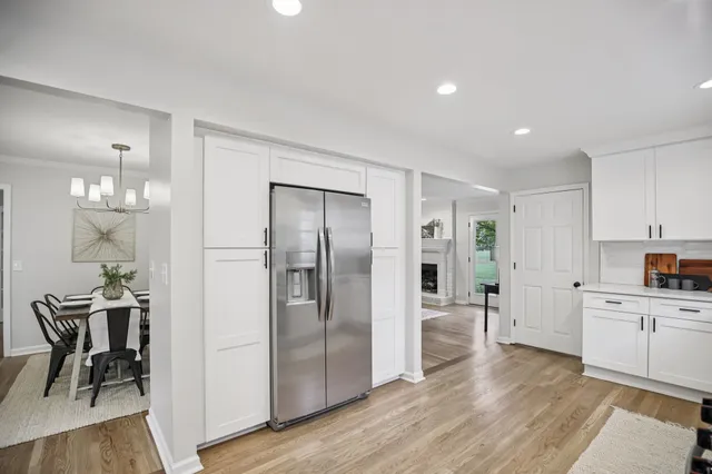 a view of a kitchen with refrigerator and wooden floor