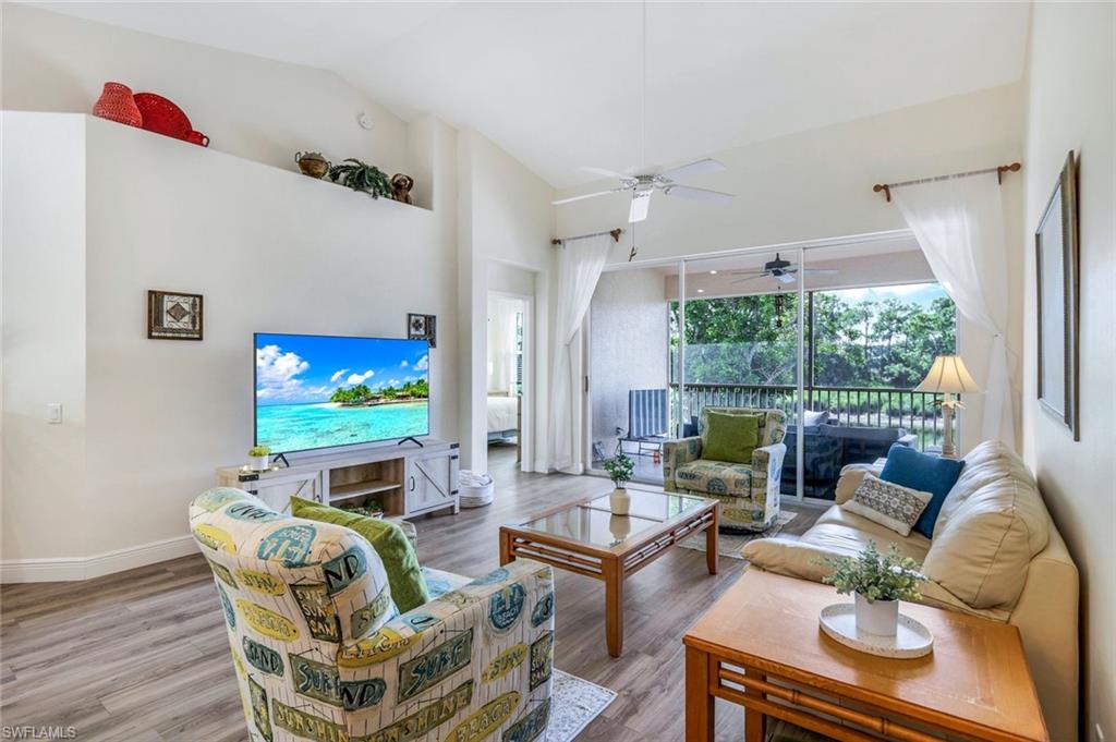 9331 Spring Run Boulevard, Unit 3003 Estero, FL 34135 - Photo 6 of 47 a living room with furniture a flat screen tv and a large window
