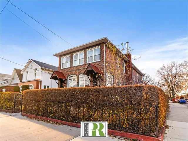 a front view of a house with large trees