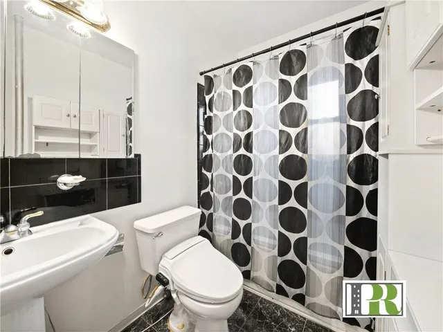 a bathroom with a sink and mirror with toilet