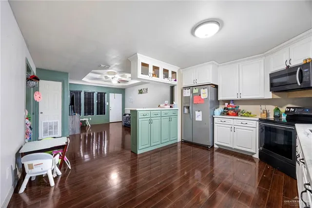a kitchen with furniture wooden floor and stainless steel appliances