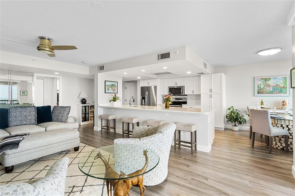 6573 Marissa Loop, Unit 1203 Naples, FL 34108 - Photo 5 of 22 a living room with furniture and a wooden floor
