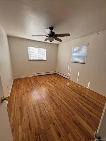 a view of empty room with wooden floor