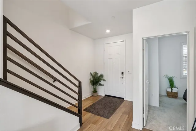 a kitchen with stainless steel appliances granite countertop a refrigerator a stove top oven a sink dishwasher and a dining table with wooden floor