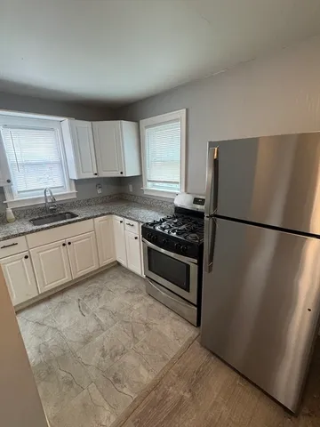 a kitchen with stainless steel appliances granite countertop a refrigerator sink and cabinets