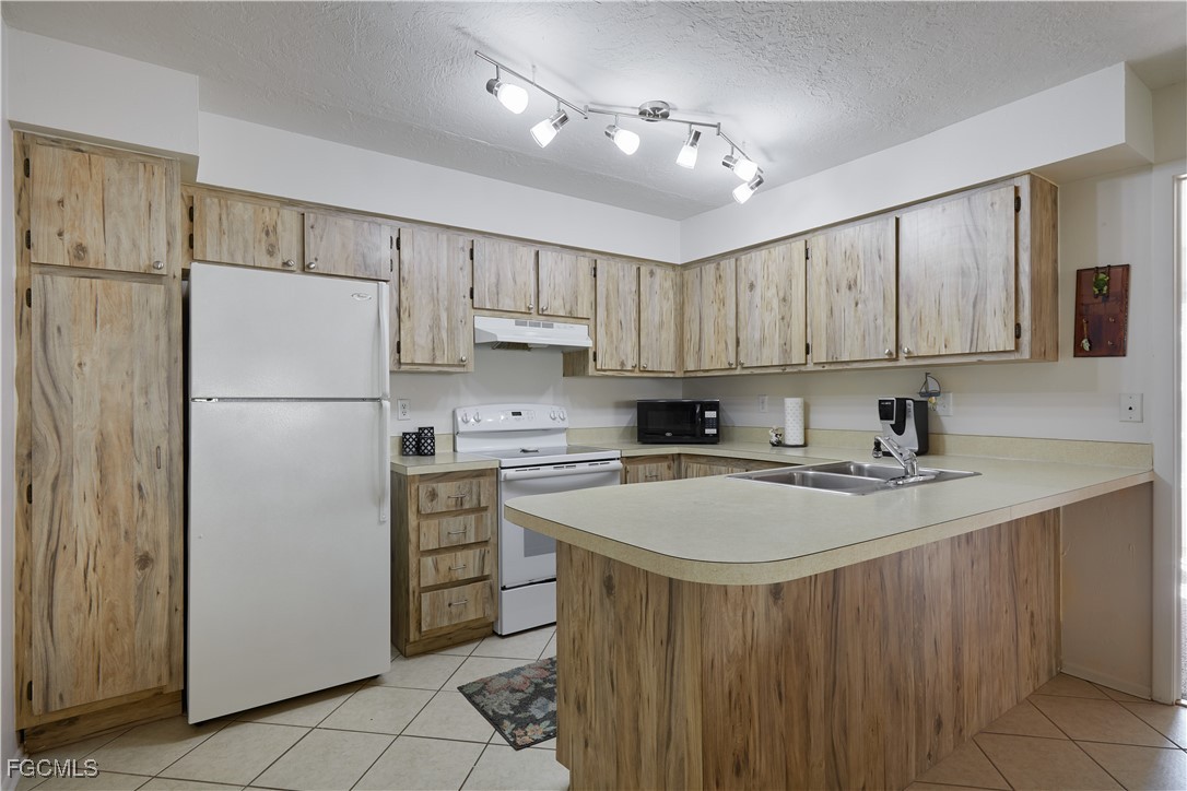 1100 Pondella Road, Unit 801 Cape Coral, FL 33909 - Photo 13 of 24 a kitchen with a refrigerator a sink and dishwasher