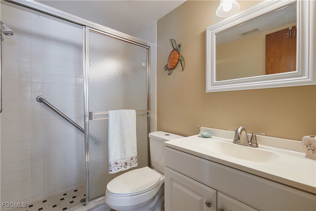 1100 Pondella Road, Unit 801 Cape Coral, FL 33909 - Photo 5 of 24 a bathroom with a sink a mirror and a toilet