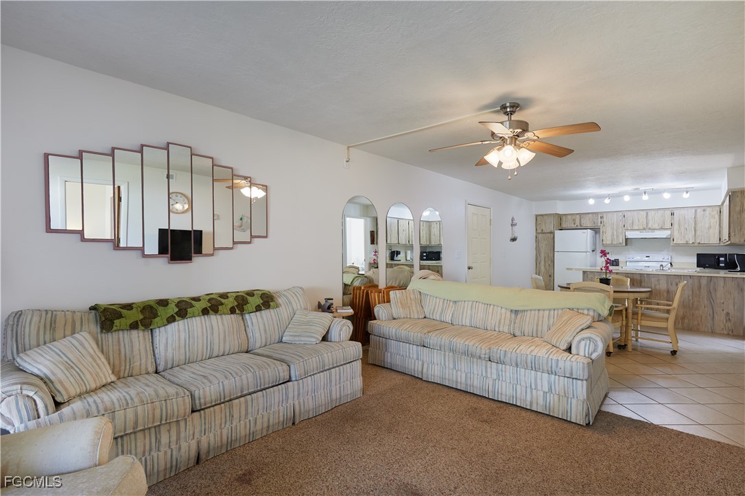1100 Pondella Road, Unit 801 Cape Coral, FL 33909 - Photo 9 of 24 a living room with furniture kitchen view and a chandelier