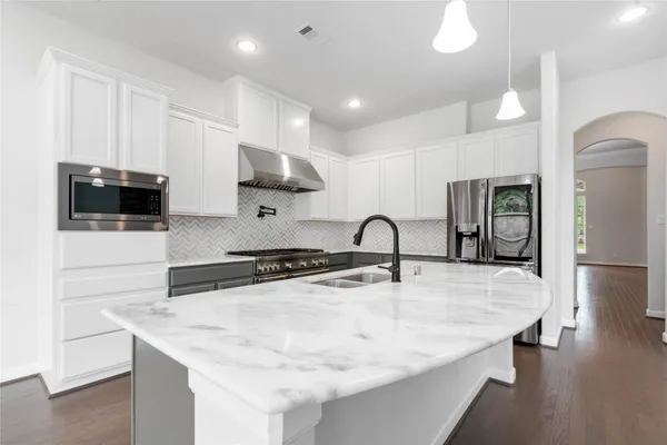 a kitchen with stainless steel appliances a sink microwave and stove
