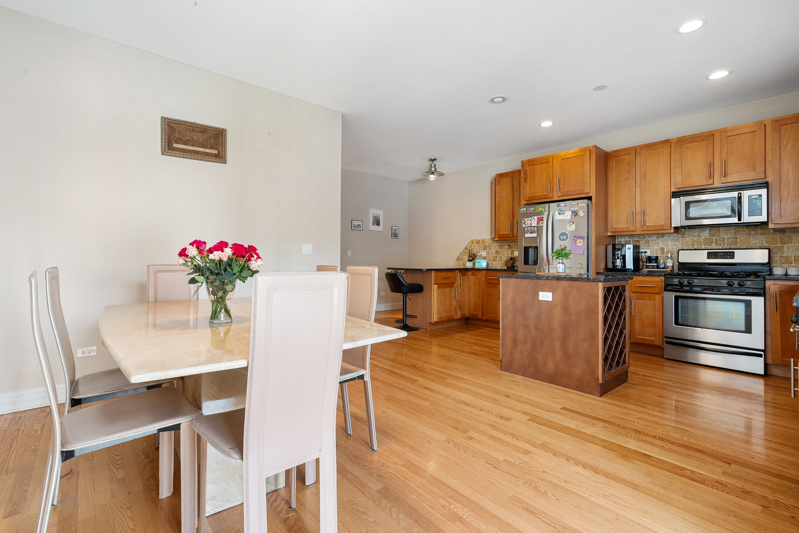 3638 North Odell Avenue Chicago, IL 60634 - Photo 15 of 46 a kitchen with stainless steel appliances kitchen island granite countertop a stove a sink dishwasher and a refrigerator with wooden floor