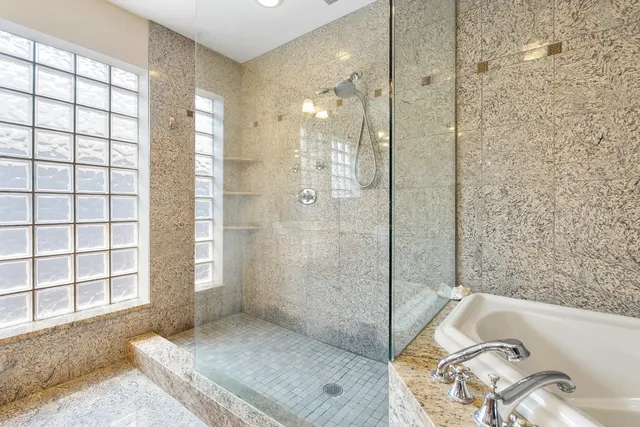 a bathroom with a tub shower and sink