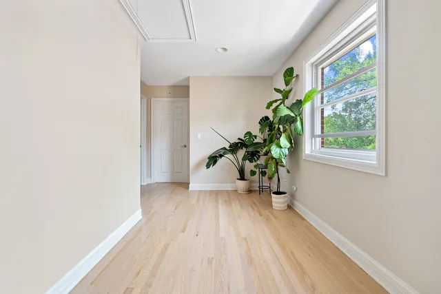 a view of a hallway with wooden floor and glass door