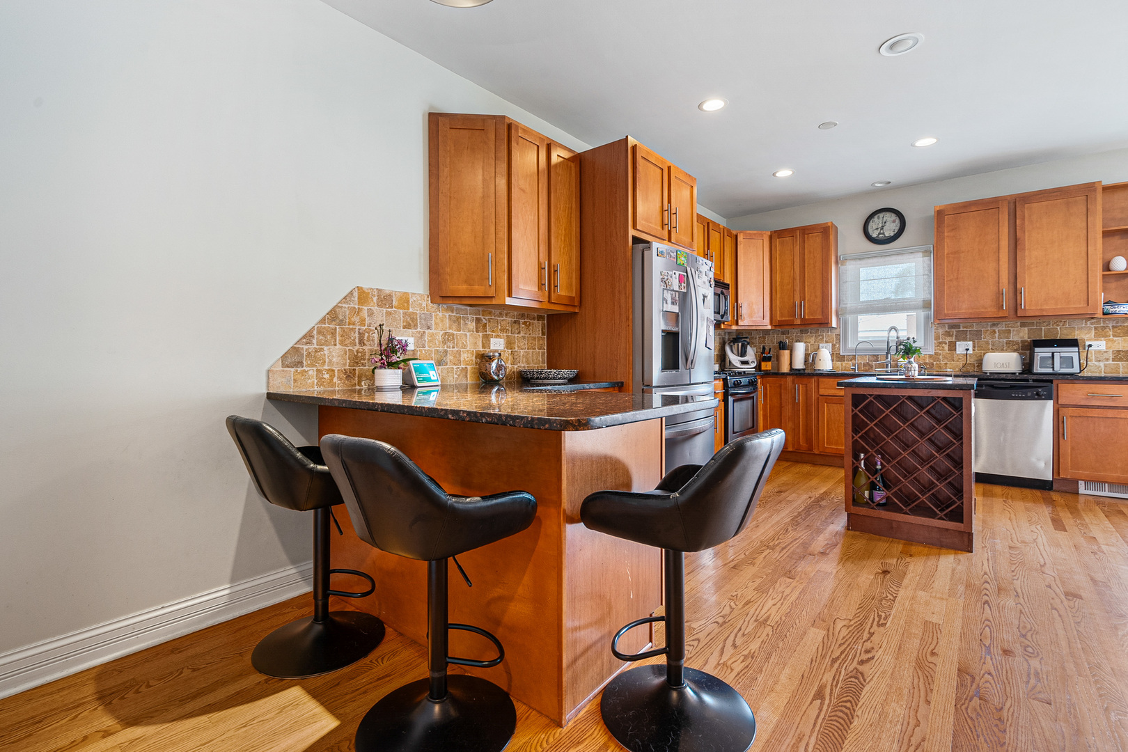 3638 North Odell Avenue Chicago, IL 60634 - Photo 9 of 46 a kitchen with stainless steel appliances kitchen island granite countertop a table and chairs in it