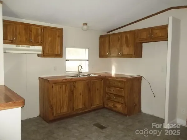 a room with cabinets a sink and a window