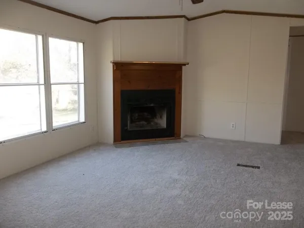 a view of an empty room with a fireplace and a window