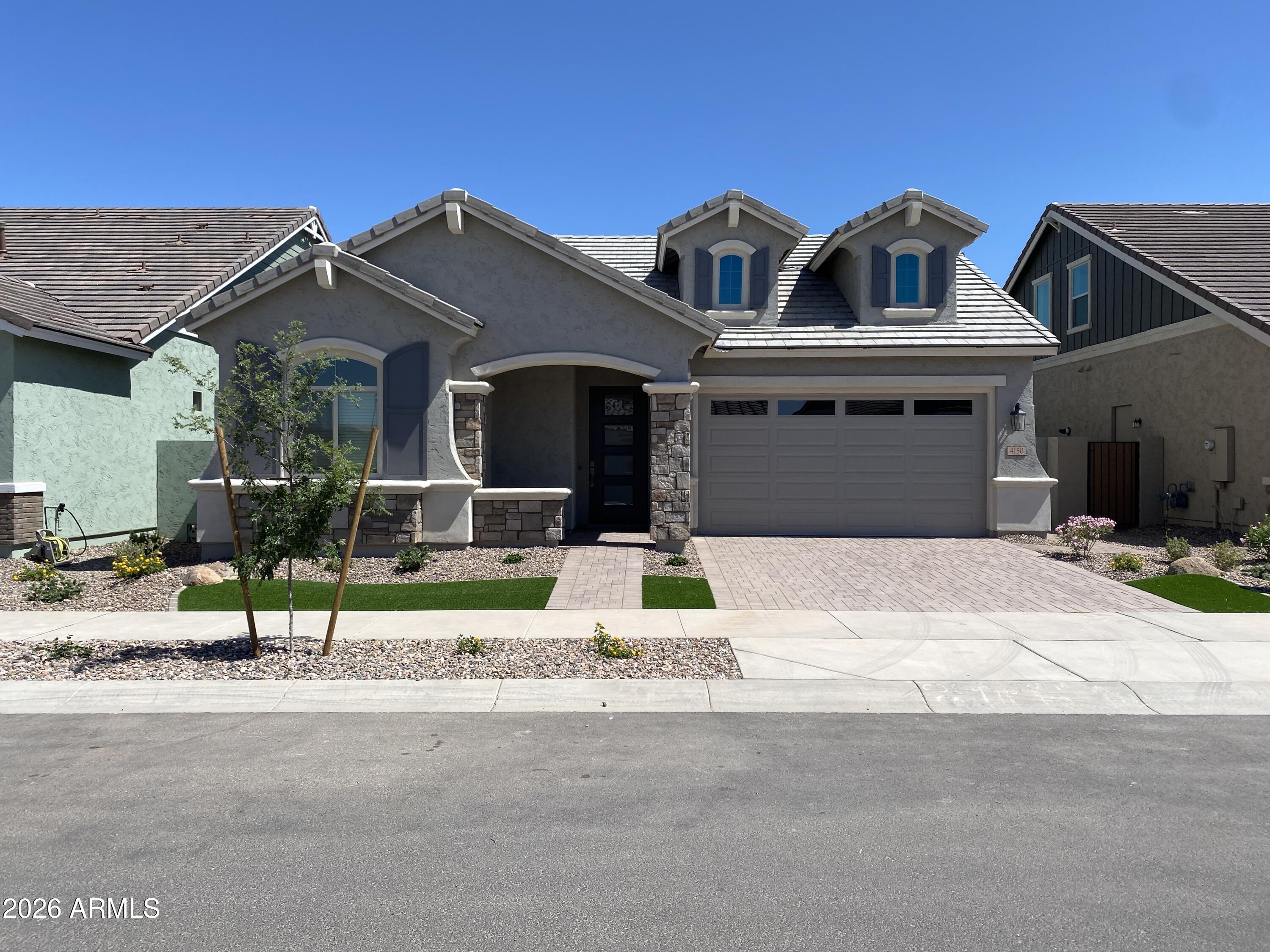 a front view of a house with a garden and plants