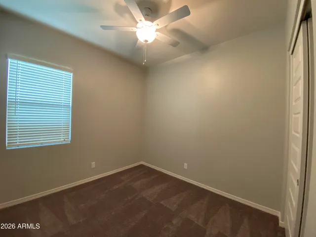 an empty room with a window and a fan