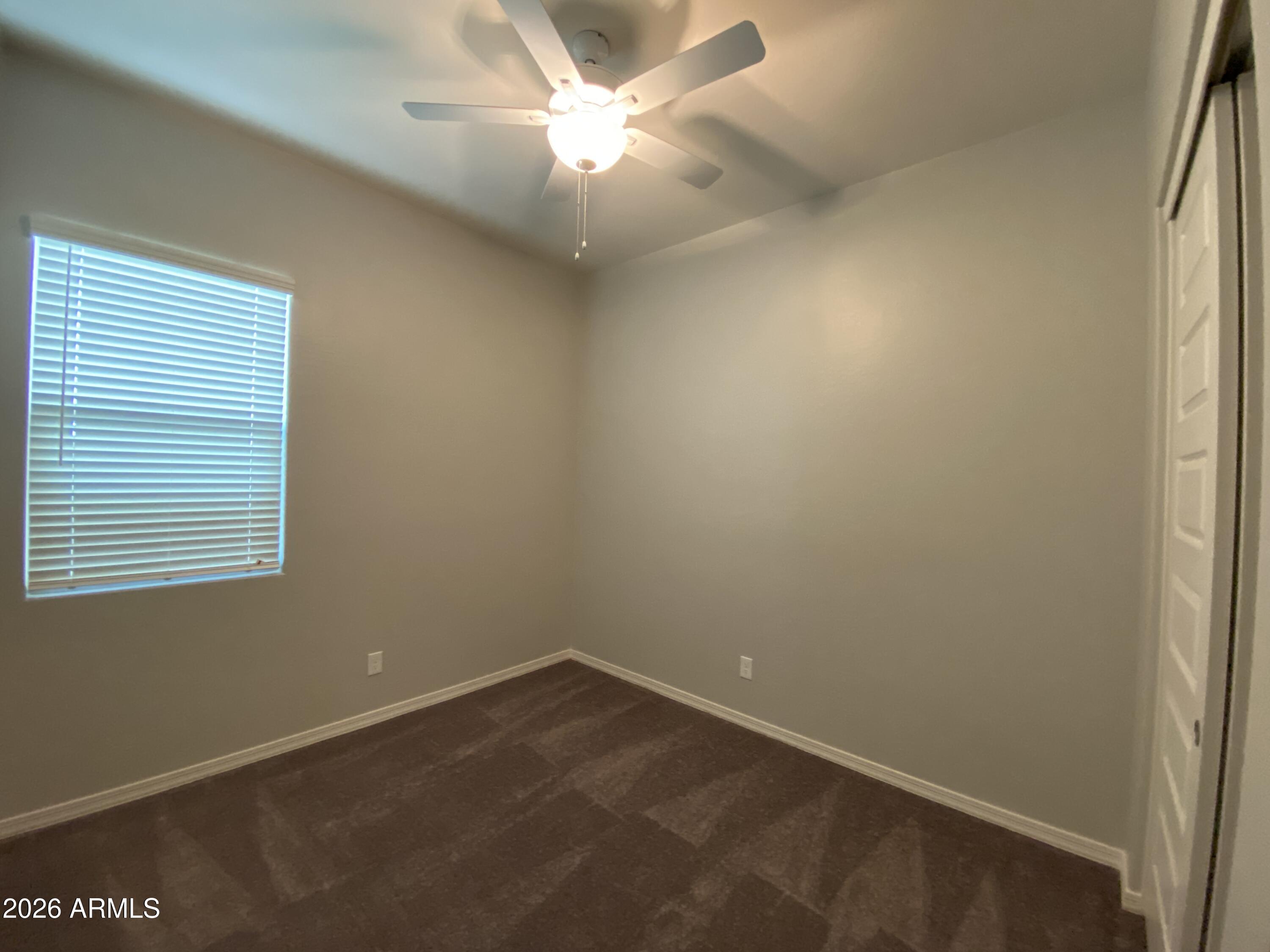 4150 East Bernice Street Gilbert, AZ 85295 - Photo 11 of 25 an empty room with a window and a fan