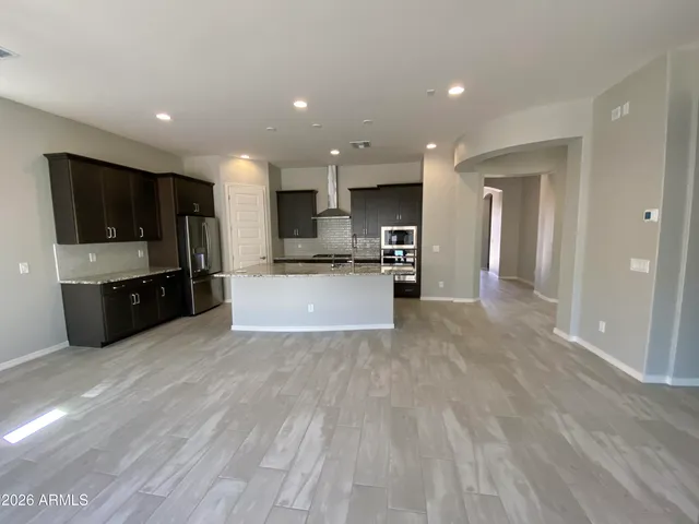 a large kitchen with stainless steel appliances a large counter top a stove and a refrigerator