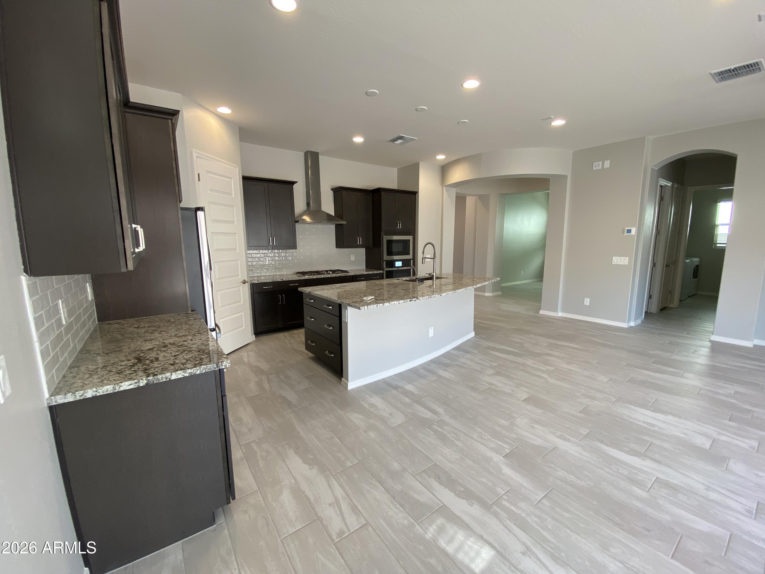 4150 East Bernice Street Gilbert, AZ 85295 - Photo 4 of 25 a large kitchen with stainless steel appliances kitchen island granite countertop a large counter top and stove
