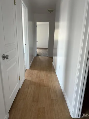 a view of a hallway with wooden floor