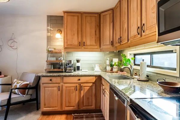 a kitchen with stainless steel appliances granite countertop a sink stove and cabinets