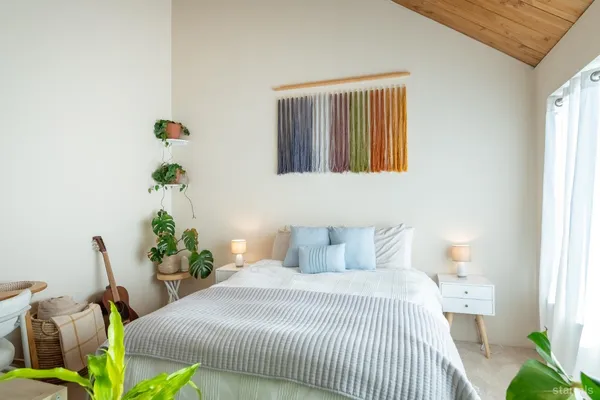 a bedroom with a bed potted plant and a window