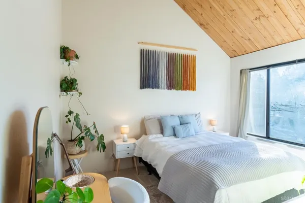 a bedroom with bed and a potted plant