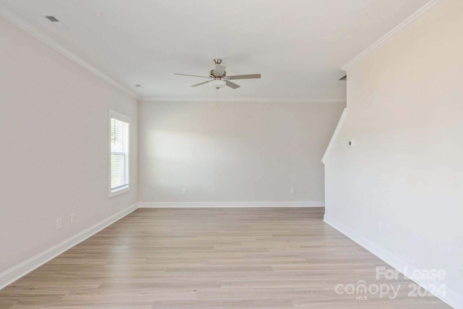 211 Adams Tree Way Troutman, NC 28166 - Photo 5 of 32 a view of an empty room with wooden floor and fan