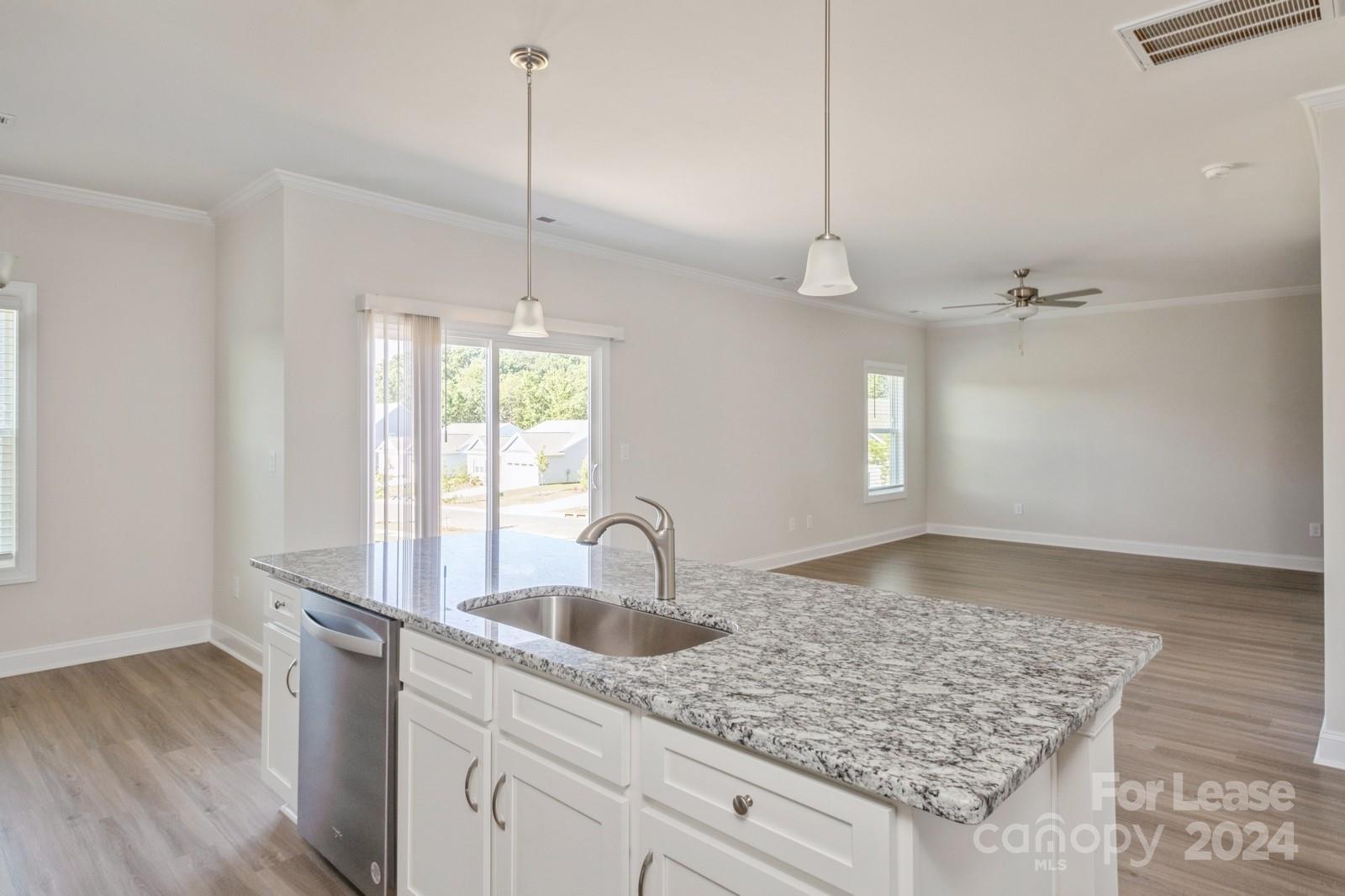 211 Adams Tree Way Troutman, NC 28166 - Photo 8 of 32 a kitchen with kitchen island a sink counter top space and living room view