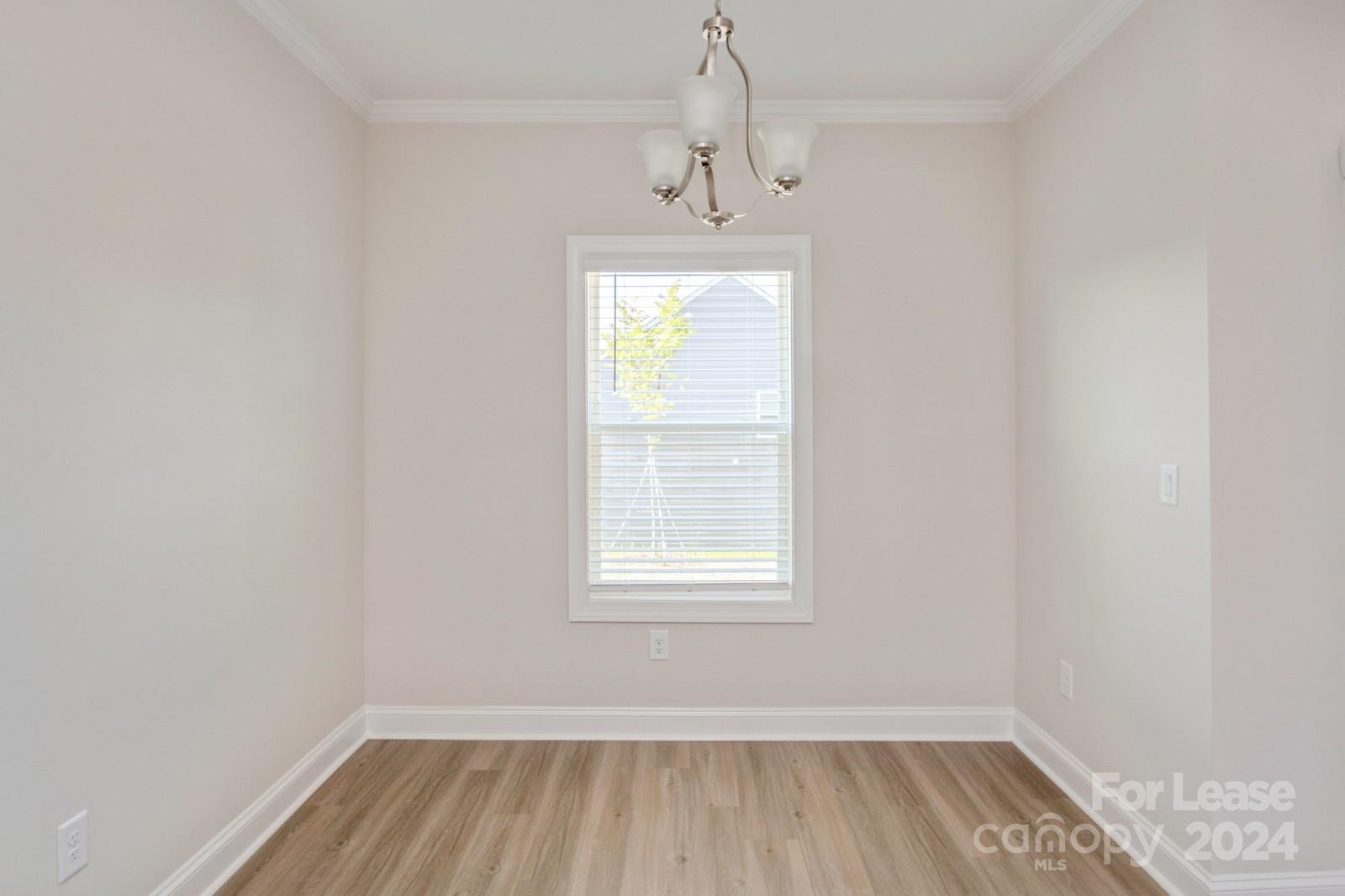 211 Adams Tree Way Troutman, NC 28166 - Photo 10 of 32 an empty room with wooden floor and windows