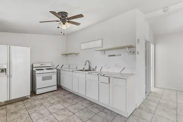 a kitchen with white cabinets and white appliances