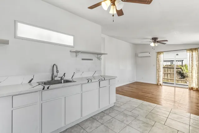 a spacious bathroom with a granite countertop sink a light fixture and a vanity