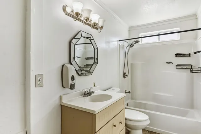 a bathroom with a sink toilet mirror vanity and shower